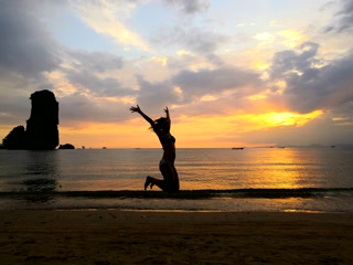 Saltando en la playa al atardecer